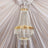 Elegant crystal chandelier with gold accents hanging from a draped ceiling.