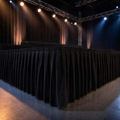 Empty event stage with black drapes and dramatic spotlights