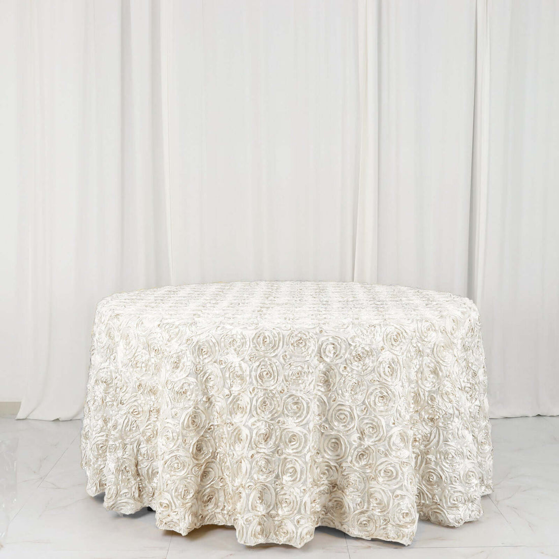 Elegant ivory rose-patterned tablecloth on a round table.