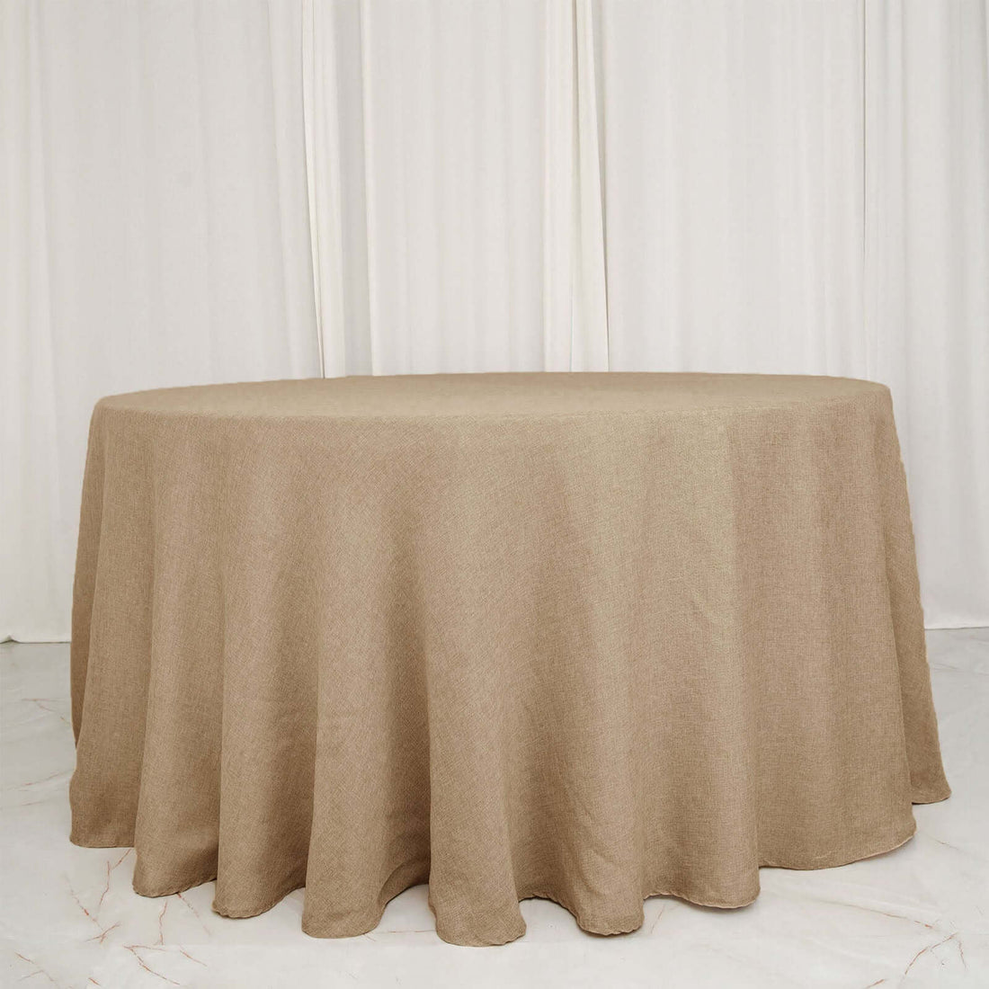 Round beige tablecloth on a plain white backdrop.