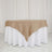 Burlap tablecloth draped over a white table skirt