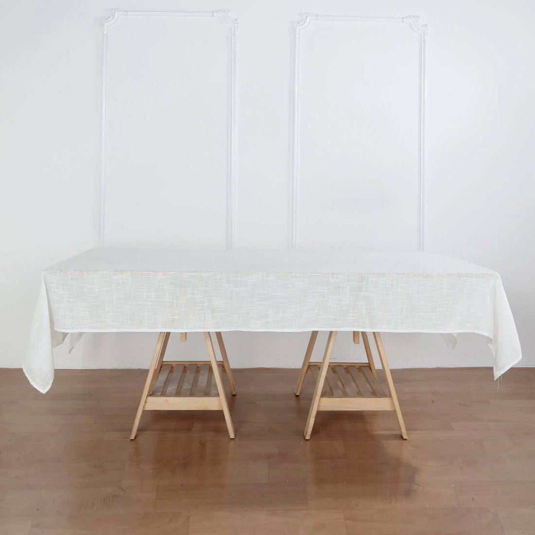 White linen tablecloth draped over two wooden tables.