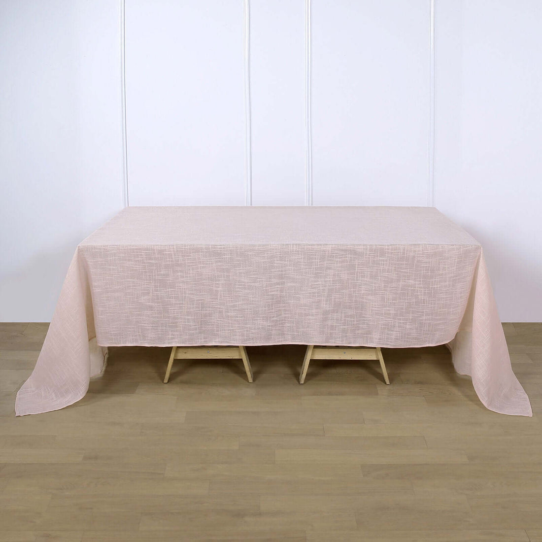 Light pink tablecloth draped over a wooden table
