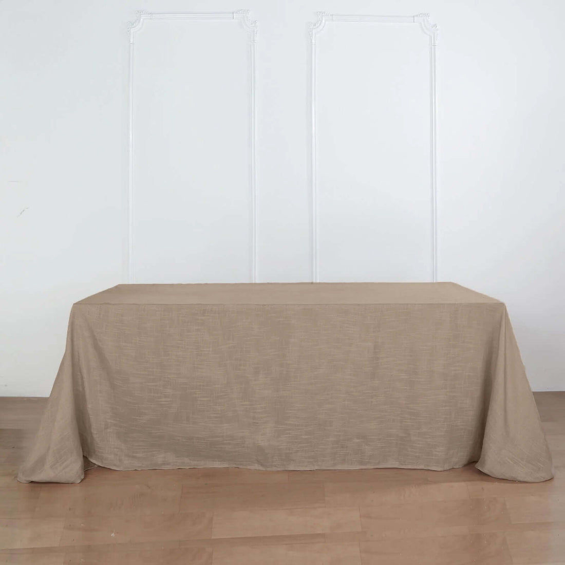 Beige tablecloth draped over a table against a plain background.