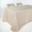 Neutral beige tablecloth draped over a table with two wooden chairs