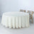 Round cream tablecloth draped over a circular table with wooden chairs.