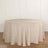 Round beige tablecloth on a wooden floor with a plain background.