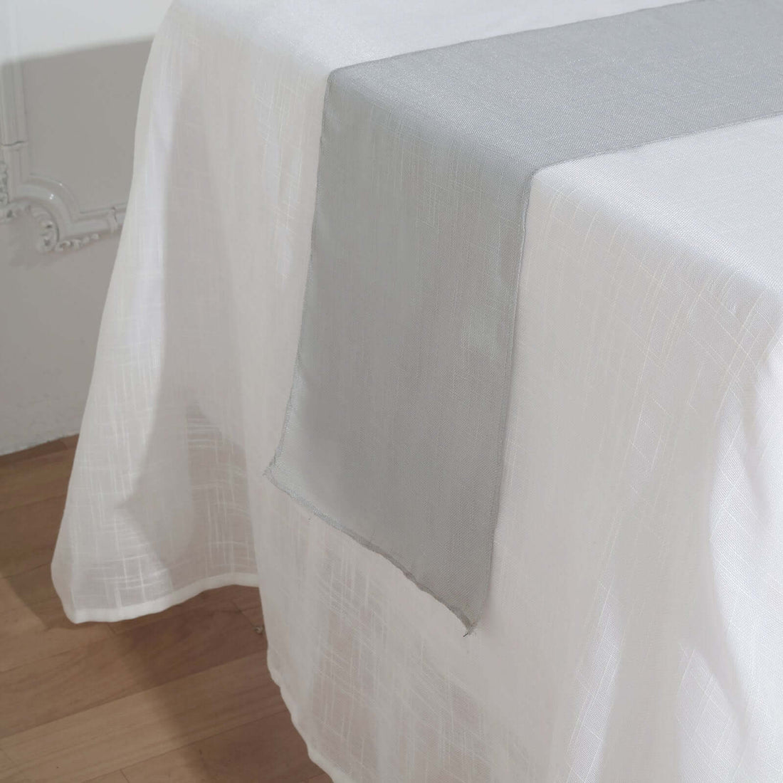 Sheer white tablecloth with gray runner on dining table