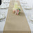 Table runner with candles and flowers on a dining table setting.