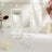 Decorative candles and water vases with floating beads on a table.
