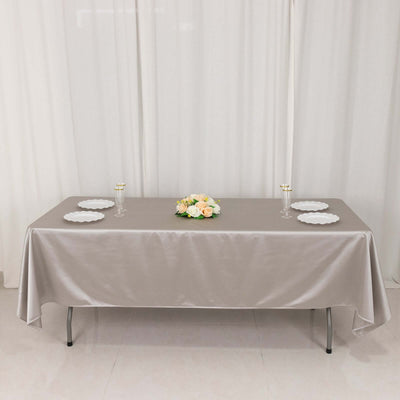 Elegant table setup with grey satin tablecloth and floral centerpiece.