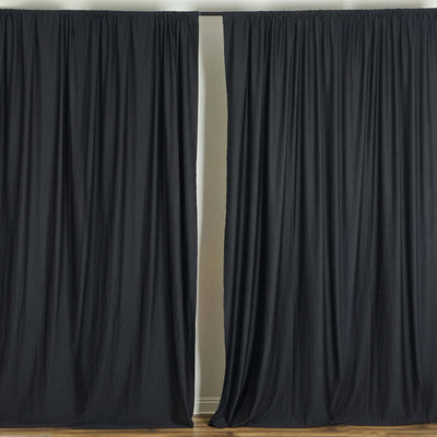 Black curtain panels neatly draped in a studio setting.