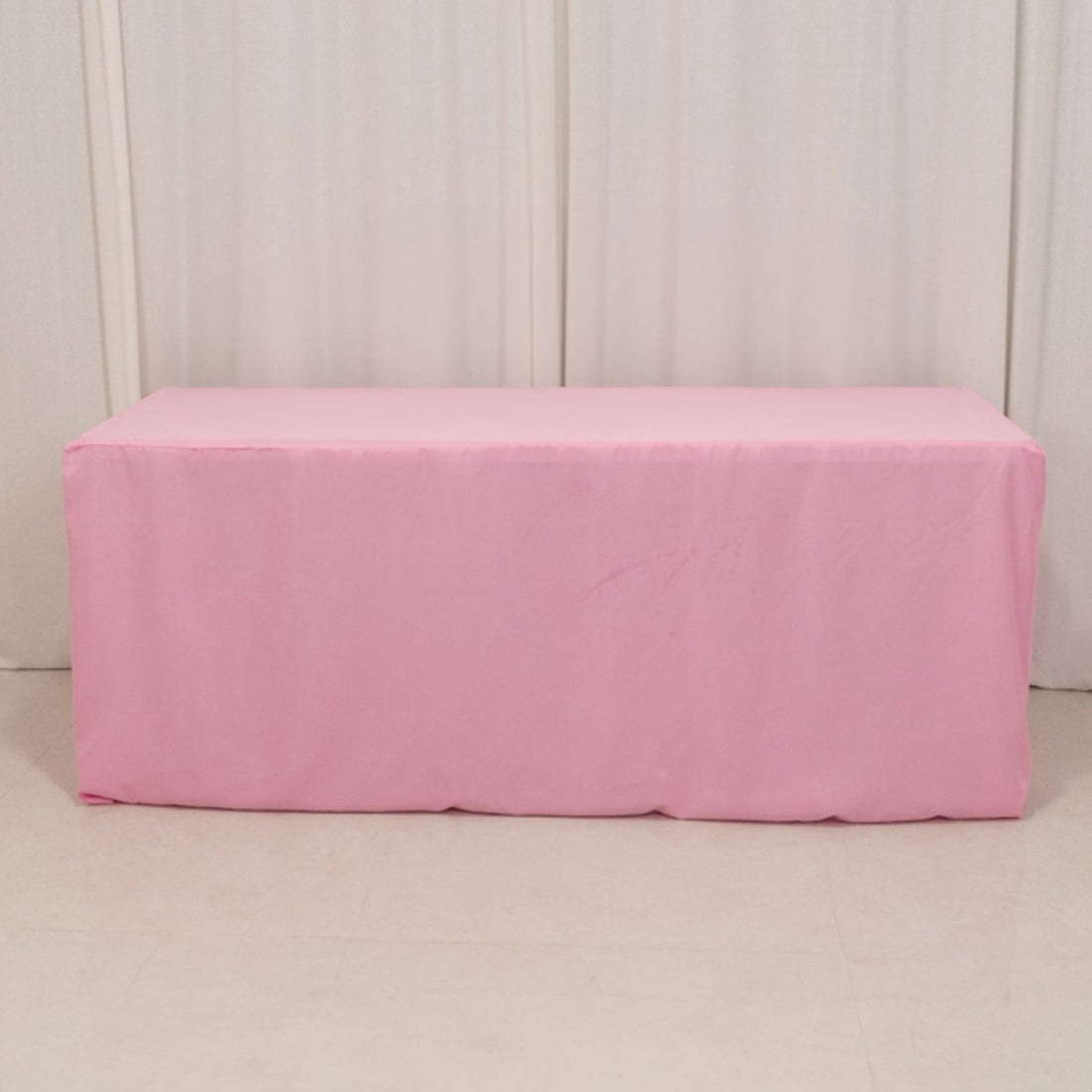 Pink table cover draped over a rectangular table.