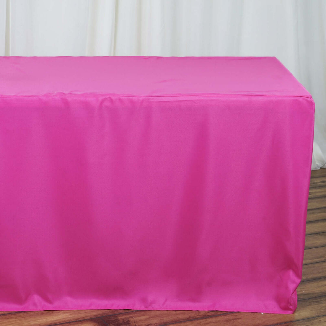Pink table cover on a wooden floor.