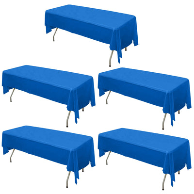 Five blue tablecloths draped over folding tables on a white backdrop.