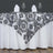 Black and white floral tablecloth draped over a table with dinnerware.