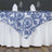 Blue and white floral tablecloth on a dining table with napkins and glasses.