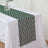 Green lace table runner on a white tablecloth.