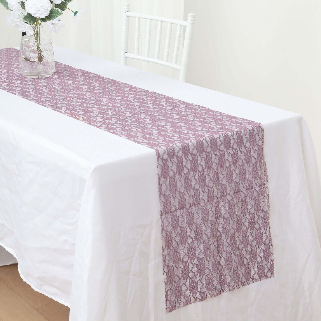 Lace table runner in mauve color on a white tablecloth