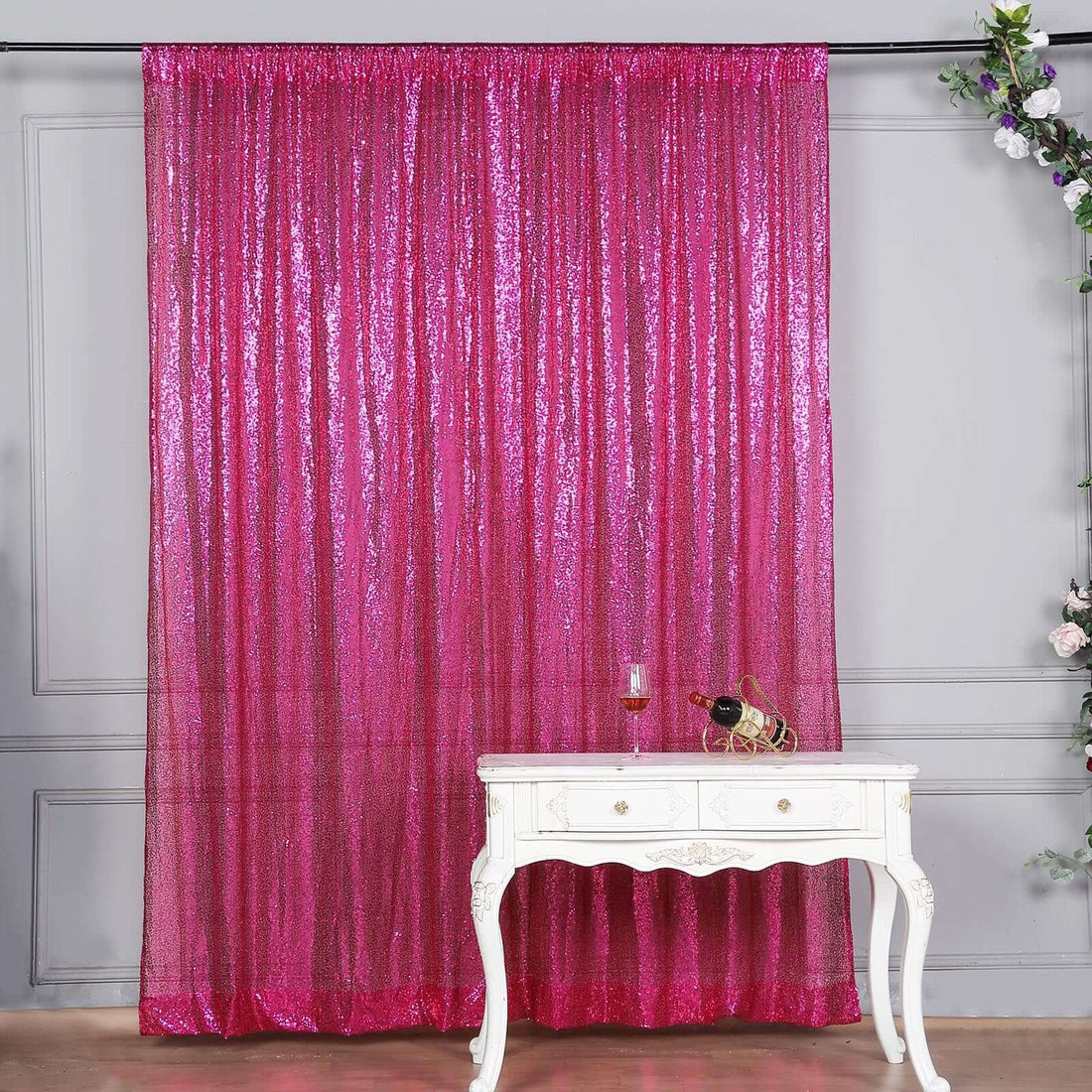 Shimmering pink sequin curtain draped elegantly on a stylish white table.
