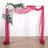 Pink fabric draped wedding arch with floral accents