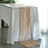 Table runner in soft beige draping elegantly over a white table.