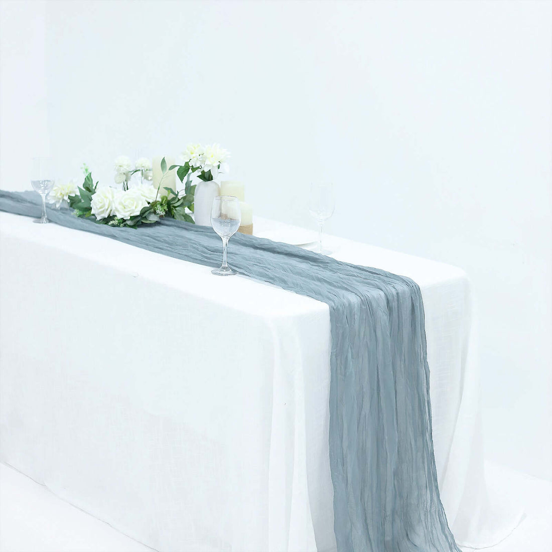 Elegant gray table runner draped over a white table with floral arrangements and glasses
