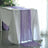 Purple table runner draped over a white table in a bright setting.