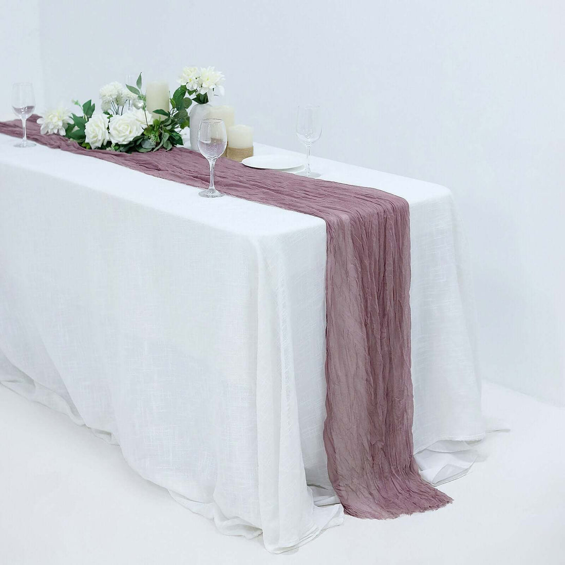 Elegant table setting with a mauve runner and floral decor