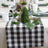 Buffalo check table runner with greenery decor and table setting.