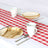 Biodegradable plates and cups on a red checkered tablecloth.