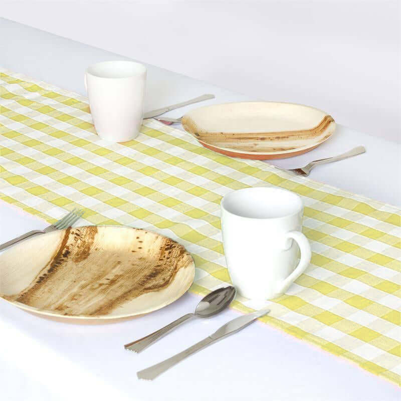 Eco-friendly wooden plates and white mugs on a yellow checkered table runner.