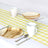 Eco-friendly wooden plates and white mugs on a yellow checkered table runner.
