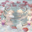 Floating candle bowl surrounded by pink rose-shaped candles and petals.