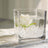 Clear glass vase with white roses and water, showcasing elegant floral arrangement.