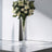 Elegant flower arrangement in a tall crystal vase.