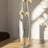 Tall glass vase with white flowers, casting soft shadows.