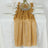 Gold table runner draped elegantly on a white tablecloth with clear dinnerware.