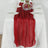 Red sheer table runner draped elegantly on a white tablecloth.
