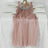 Pink shimmering table runner on a white table with elegant dinnerware.