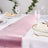 Elegant table setting with pink and white table runners and glassware.