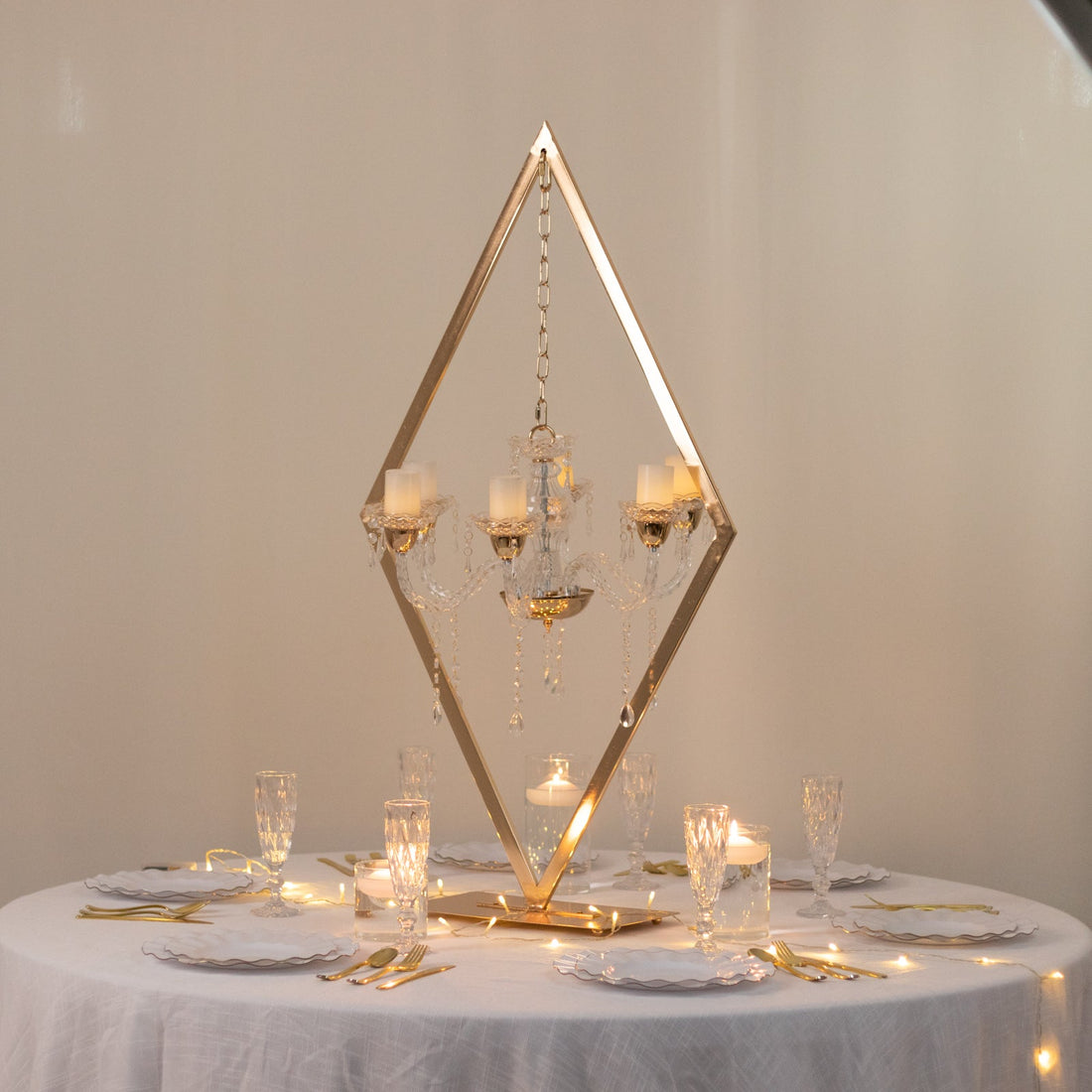 Elegant chandelier centerpiece with candles and crystal accents on a decorated table.