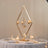 Elegant chandelier centerpiece with candles and crystal accents on a decorated table.