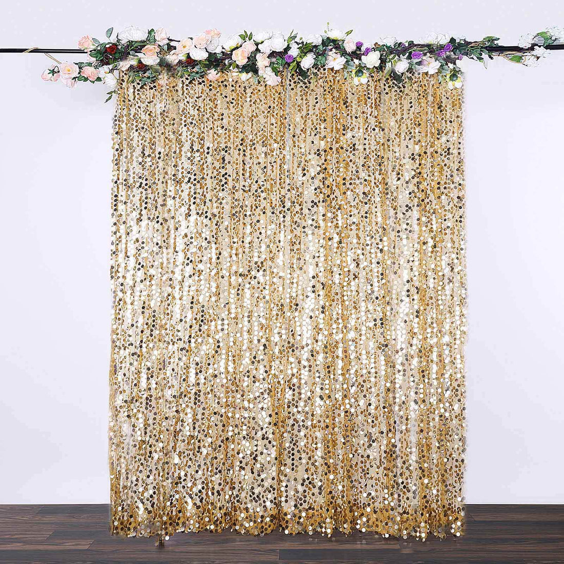 Gold sequin curtain with floral top decoration for events and parties.