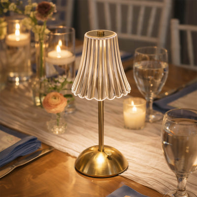 Gold cordless table lamp on elegant candlelit dining table setting