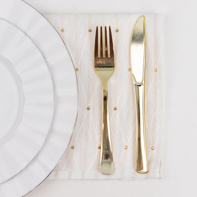 Gold cutlery setting with white plates and sheer embroidered napkin