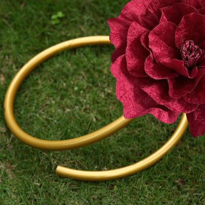 Gold garden hose and red flower on green grass background
