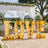 Gold illuminated LOVE sign at outdoor wedding reception under floral canopy