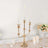 Gold candelabra with three candles on a decorated table.