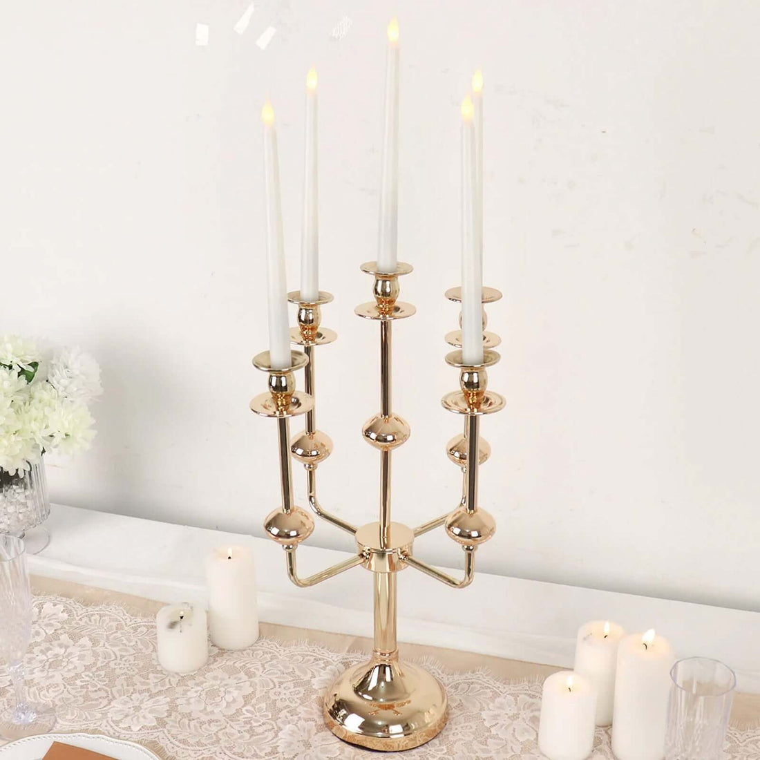Elegant gold candelabra with five candle holders and white candles.